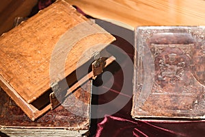 Ancient books in leather binding with copper locks on the table