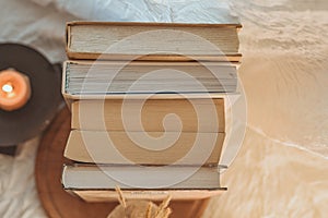 Ancient books with two burning candle on white background