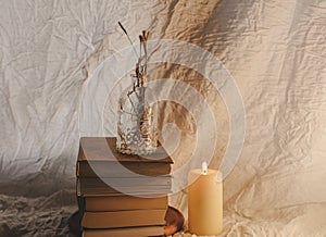 Ancient books with two burning candle on white background