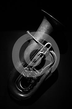 An ancient brass tuba in black and white