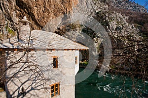 Ancient brick building of historical Sufi monastery Blagaj Tekke with a river and the mountains around