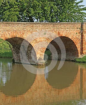 ancient bridge made of red brick on the river in Europe