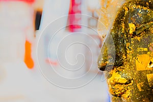 Ancient Buddha face with gold leaf