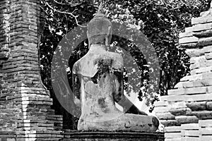 Ancient buddha statue in archaeological site at Wat Mahathat temple . old sculpture in history is a world heritage . black and