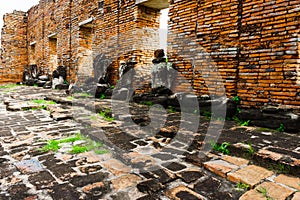 The Ancient Buddha statue articulate are red brick wall .