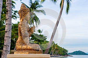 Ancient buddha statue among coconut trees