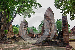 Ancient Buddha Statue,Khmer-style prangs and ruins at Wat Mahathat,Phra Nakorn Sri Ayutthaya,Thailand.A UNESCO World Heritage Site