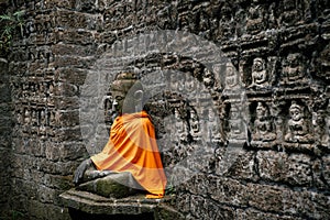 Ancient Buddha statue in orange cover