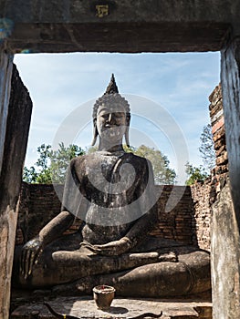 Ancient Buddha statue in ruined temple in Thailand