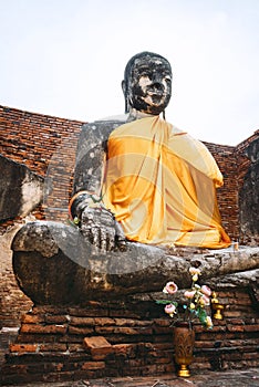 Ancient Buddha statue with shiny yellow robe, in Ayutthaya, Thai