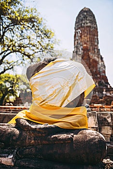 Ancient Buddha statue with shiny yellow robe, in Ayutthaya, Thai