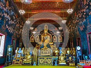 Ancient Buddha statue in Thailand with mural painting around.