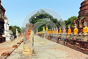 Ancient buddha statues face to face and ruins of Wat Yai Chaimongkol temple in Ayutthaya, Thailand.