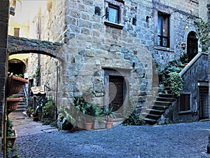 Ancient building, stairway and arch. Plants, history and time in Viterbo city, Italy