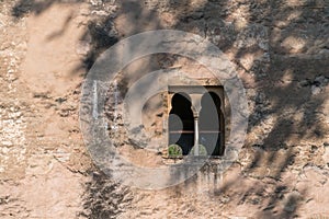 Ancient building wall with Arabic style window in the shadow