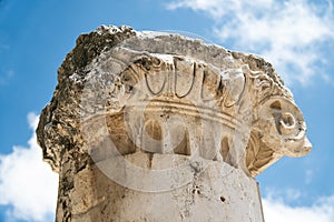 Ancient capital of a column on the blue sky background close up