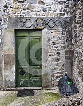 Ancient carved door and stone doorway with carving, in a small village in Lunigiana, north Tuscany, Italy.