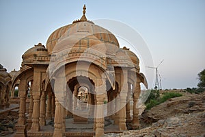 Ancient cenotaph with modern windmills in bada baag Jaisalmer Rajasthan India