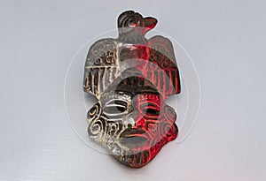 An ancient ceramic pre columbus mask based in American indigenous tribes art iluminated by red and white lights photo