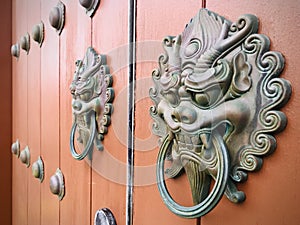 Ancient Chinese architecture door and copper dragon head door knockers on it.