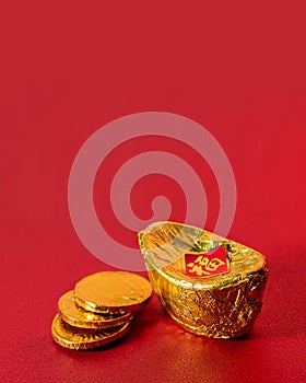 Ancient Chinese Gold Ingot with Three Golden Coins Made From Alumunium Foil on Red Background For Chinese Lunar New Year Greeting