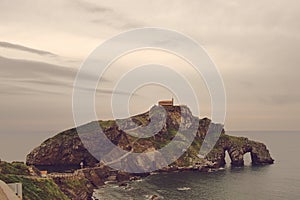 Ancient church on an island hill, San Juan de Gazteluatxe, Vizcay, Spain photo