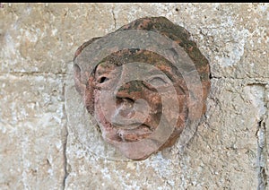 Ancient Clay face sculpture on the wall of a walkway in the Masseria Torre Coccaro