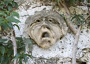 Ancient Clay face sculpture on the wall of a walkway in the Masseria Torre Coccaro