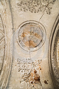 Ancient clay molding and floral painting on ceiling with cracks of old castle