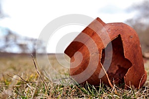 Ancient clay pot is split in the field. Tile age-old abandoned. Clay pot is broken photo