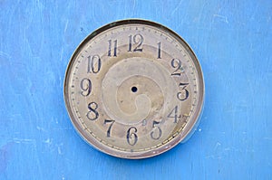 Ancient clock face dial on blue background