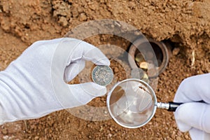 Ancient coins and magnifier.