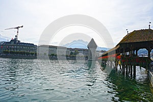 Ancient covered wooden Chapel Bridge Kapellbrucke and Water Tower Wasserturm on the background of the Pilatus Mountain Lucerne ,