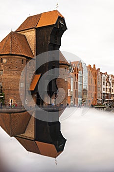 Ancient crane - zuraw Old town in Gdansk. The riverside on Granary Island reflection in Moltawa River. Visit Gdansk