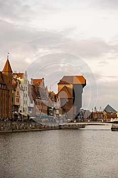 Ancient crane - zuraw Old town in Gdansk. The riverside on Granary Island reflection in Moltawa River. Visit Gdansk