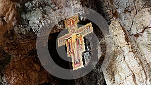 Ancient crucifix hanging from the top of a cavern