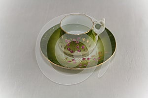 Ancient cup and saucer on white background