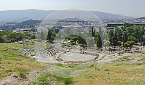 Ancient Dionysus theater under the ruins of Acropolis, with view over the city of Athens, Greece, in summer sunny day