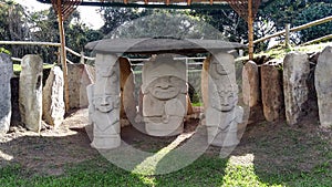 An ancient dolmen with a priest or chaman holding a human hearth with two warriors both sides at Colombian San Agustin archaeologi