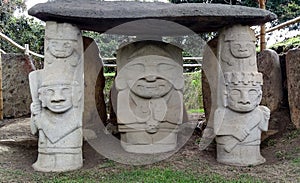 An ancient dolmen with a priest or chaman holding a human hearth with two warriors both sides at Colombian San Agustin archaeologi