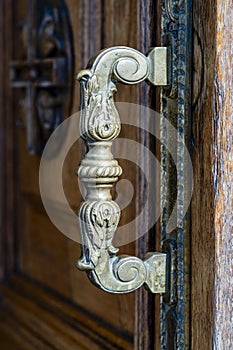 Ancient door handle on a wooden door in church, Kyiv, Ukraine. Closeup