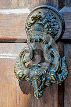 Ancient door knocker on a wooden door