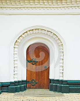 Ancient door in a white wall