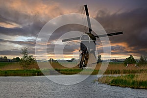 Ancient Dutch windmill in a countryside of Kinderdijk at sunset, Netherlands, Holland, rural landscape, lifestyle