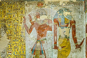 Ancient egyptian painting of two gods in a tomb in the valley of