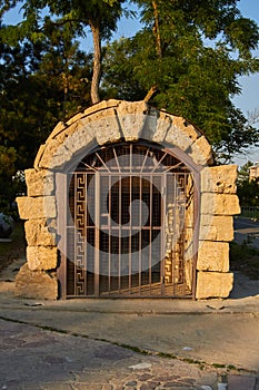 Ancient entrance with metal door to the old stone cellar