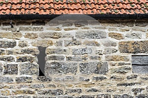 Ancient exterior stonework wall showing a vertical slot.