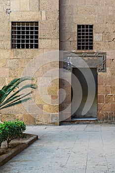 Ancient external old decorated bricks stone wall with windows and opened door photo