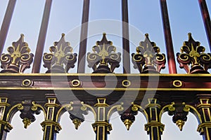 Ancient forged fence decorated with intricately regal ornaments