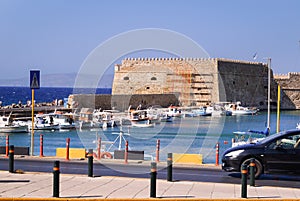 Ancient fortress at the sea port of Agios Nikolaos city, Crete island, Greece at hot summer noon.